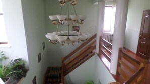 A staircase with a wooden handrail and white columns, leading to an upper floor. - Vacation House - Hostel (Kochkor)