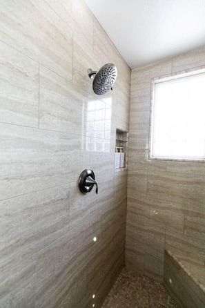 A shower with a handheld showerhead, a wall-mounted control, and a window providing natural light. - Luxurious Home w/Hot Tub & Pool + Water Slide (San Diego)
