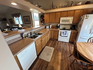 A kitchen with wooden cabinets, a microwave, a stove, and a dishwasher.