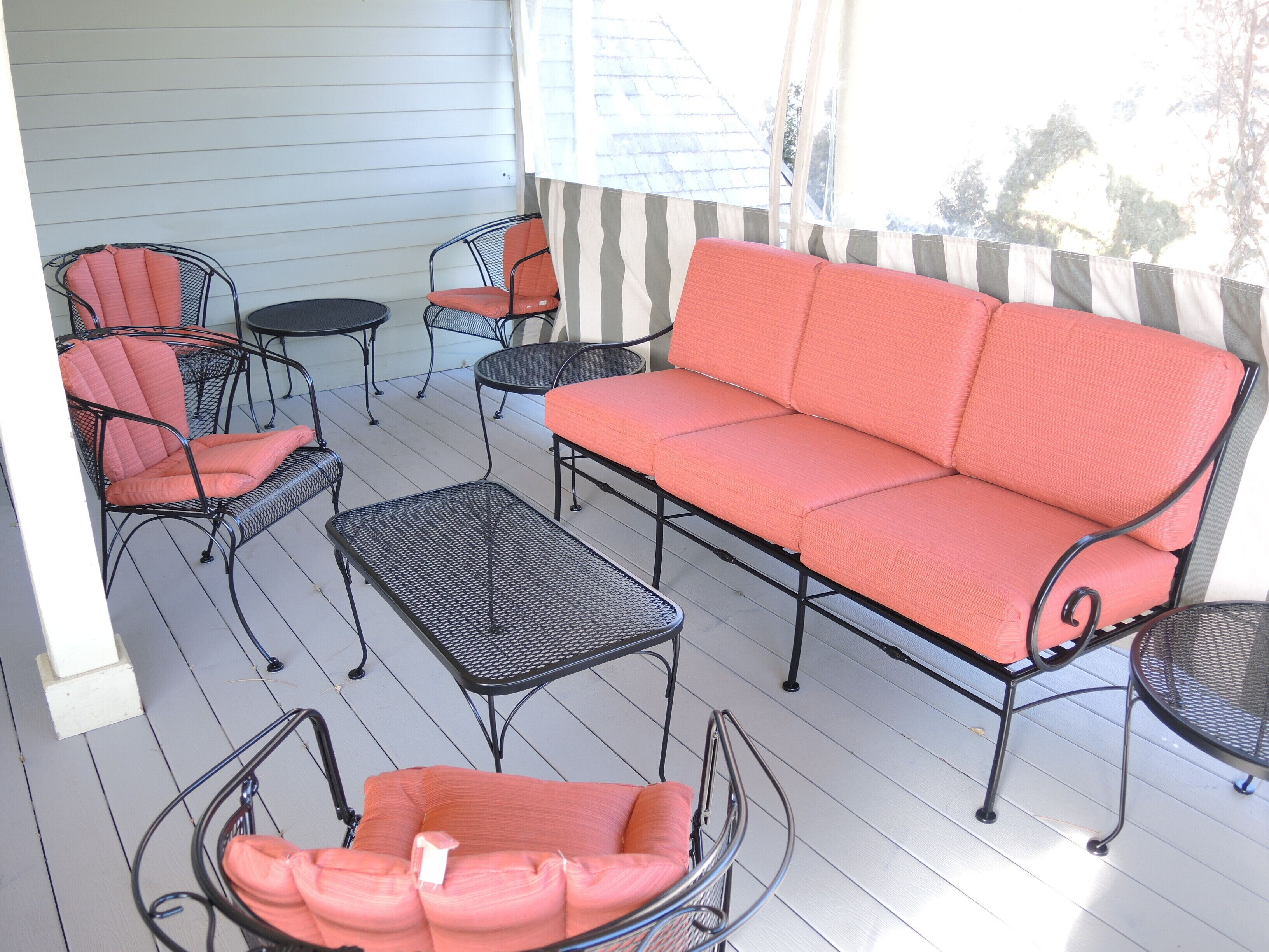 Un patio abrité comprenant un canapé, des fauteuils et une petite table.