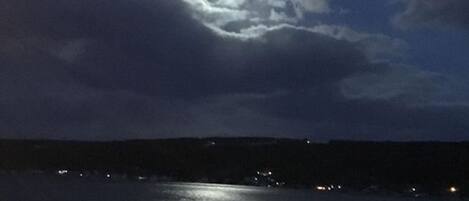 Vista nocturna de un muelle con barandilla junto al agua.