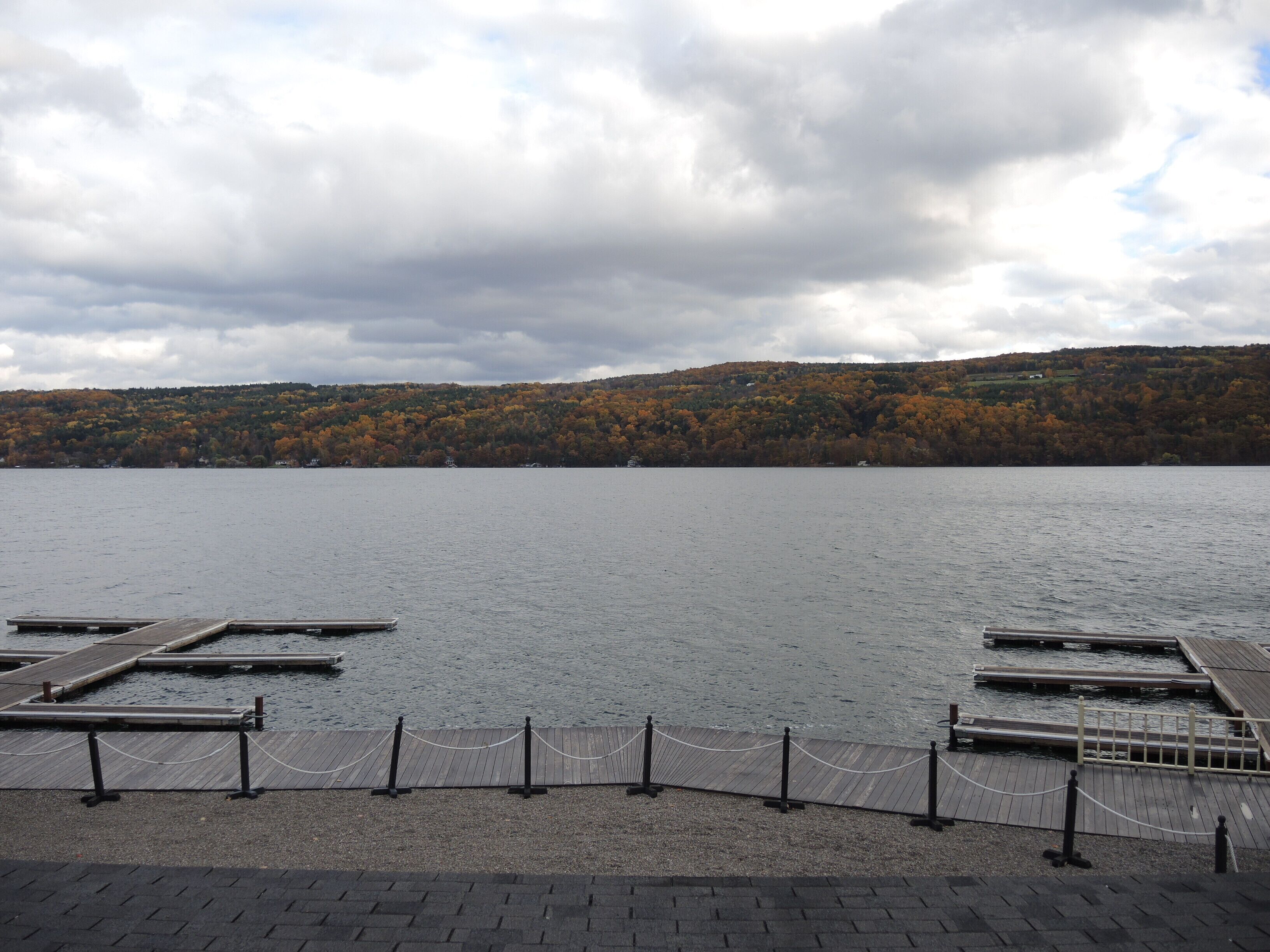 A lakeside dock area with wooden walkways and a rope barrier.