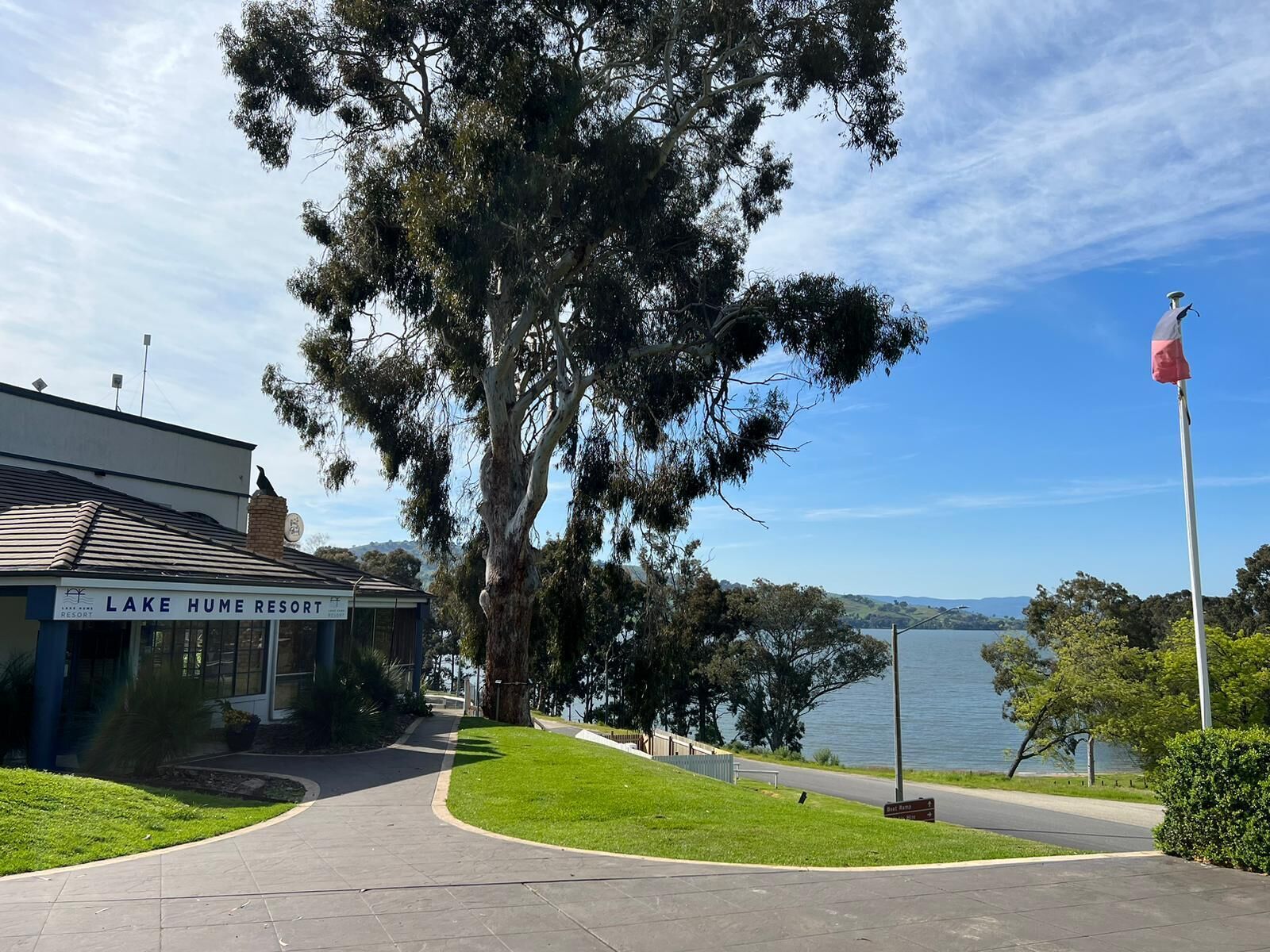 A building labeled "Lake Hume Resort" with a paved walkway leading to a body of water.