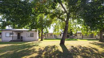 Filera de cases mòbils amb un pati enjardinat i arbres que donen ombra.