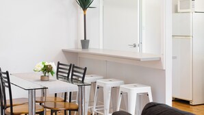 Una cucina moderna con un frigorifero bianco, un forno a microonde e una pianta in vaso sul piano di lavoro.