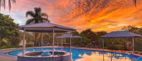 Una piscina al aire libre, sillones reclinables de piscina