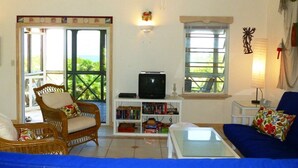 A living room with a television, bookshelf, and a sofa. - Chill Out, Relax And Reconnect In A Sweet Cottage By The Beach (Whitby)