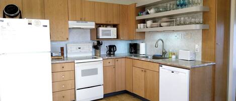 A modern kitchen with wooden cabinets, a white refrigerator, a microwave, a stove, and a dishwasher.