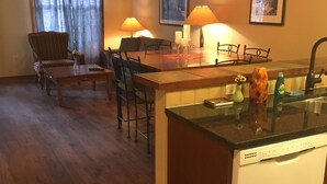 Una cucina moderna con lavastoviglie, piano di lavoro in legno e zona pranzo con sedie e tavolo.