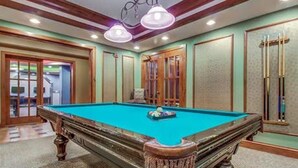 Un tavolo da biliardo in una stanza con pannelli di legno e una tappeto decorato.
