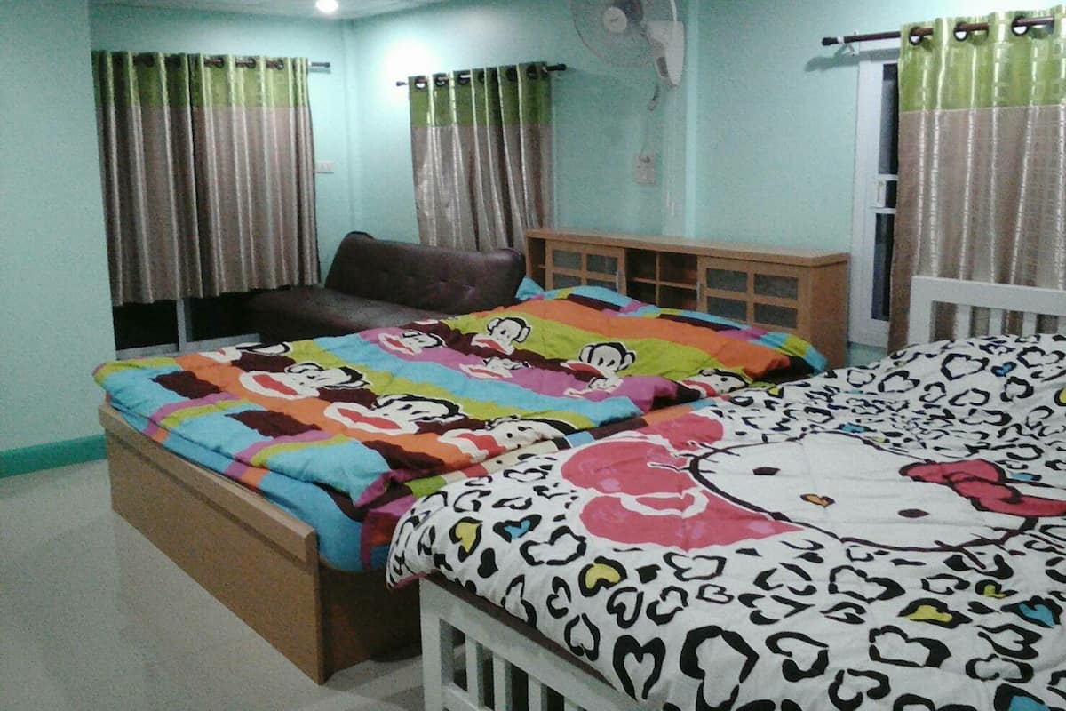 Une chambre à coucher avec un lit, une chaise, un ventilateur et des rideaux.