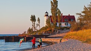 Una playa con un faro y un edificio de techo rojo.