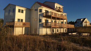 Un edificio de varios pisos con balcones, cerca de una playa.