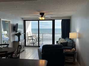 Enjoy ocean views from the spacious living area with a dining table, sofa, and armchairs.