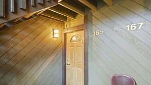 A wooden staircase leading to a door with the number 165. - Sunshine Village 165- Centrally Located, Near Eagl (Mammoth Lakes)