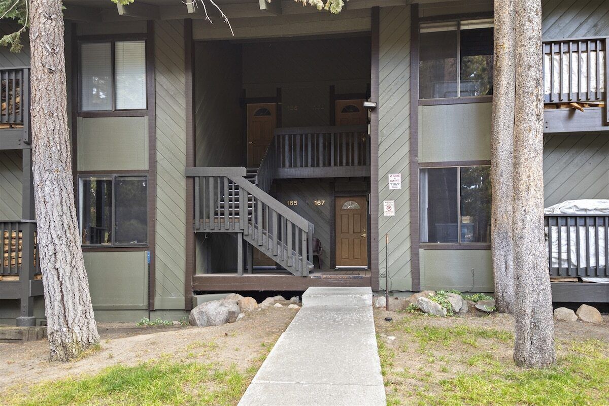 A two-story building with a wooden staircase leading to the entrance.