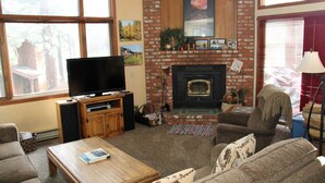 Ein Wohnzimmer mit Kamin, Fernseher und einer Couch.