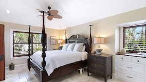 A bedroom with a four-poster bed, a ceiling fan, a nightstand with a lamp, and a window with blinds. - SERENITY - Luxury Captiva Home, 4 Homes From the Beach (Captiva)