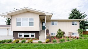 A two-story modern house with a front porch, a small garden, and a well-maintained lawn. - The Last Best Place With Mountain Views (Bozeman)