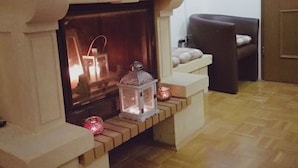 Une cheminée avec un manteau de cheminée, un téléviseur et un tableau encadré au-dessus.