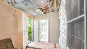 A hallway with a wooden bench, a door labeled "Laundry", and a welcome mat.