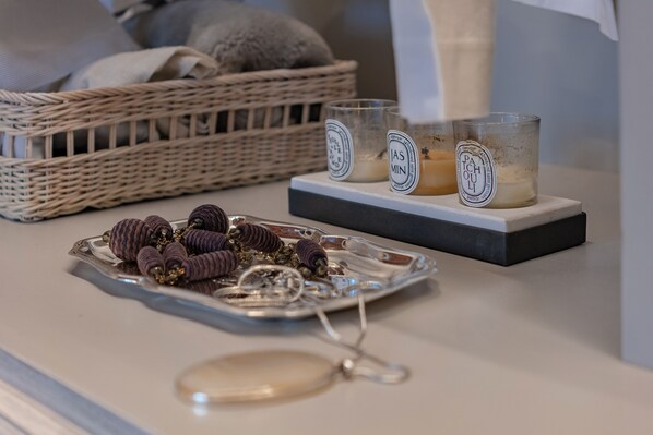 A tray with decorative items, a wicker basket, and candles on a table.