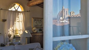 A cozy room with a view of a historic building through a window.