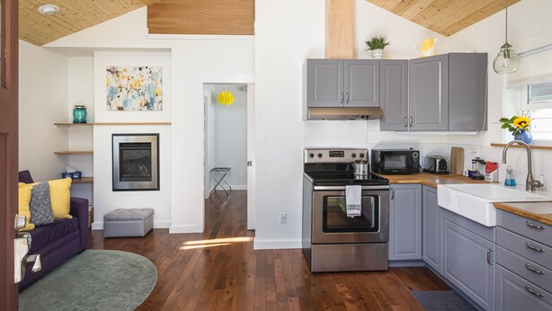 A modern kitchen with grey cabinets, a stainless steel oven, and a microwave. - Charming Fireplace! Walk to Alberta Arts SilverStar cottage in NE Portland. (Portland)