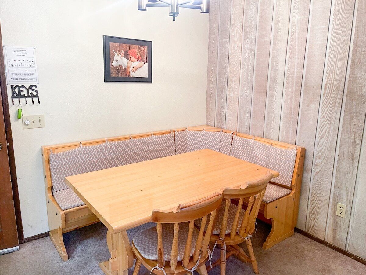 A corner dining area with a wooden table and bench seating.