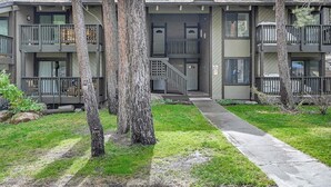 A two-story building with a covered walkway, large windows, and a balcony on the upper floor. - Sunshine Village 157: Pet Friendly, Centrally Loca (Mammoth Lakes)