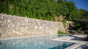 A stone wall pool with clear blue water, surrounded by greenery and a stone wall. - a place where stress doesn't exist  (Grižane)