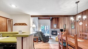 Una cocina moderna con encimera verde, armarios de madera y lavavajillas integrado.