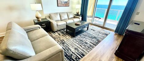 Ein Wohnzimmer mit Sofa, Couchtisch und einem Gemälde an der Wand.
