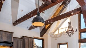 Eine Küche mit Holzbalken, einer Bar mit Hockern und großen Fenstern mit Blick.