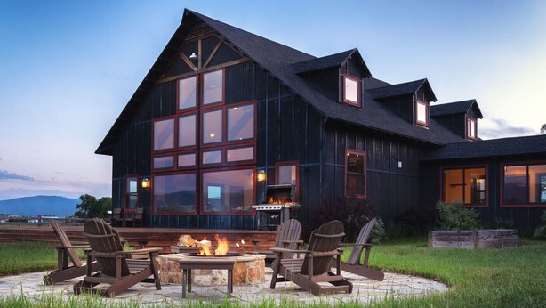 Ein großes Holzhaus mit Kamin und Außenbereich.