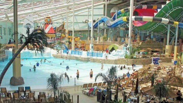Un parc aquatique intérieur doté d’une grande piscine, de toboggans et d’espaces de détente.