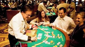 Une salle de casino avec de nombreuses tables de blackjack et des joueurs.