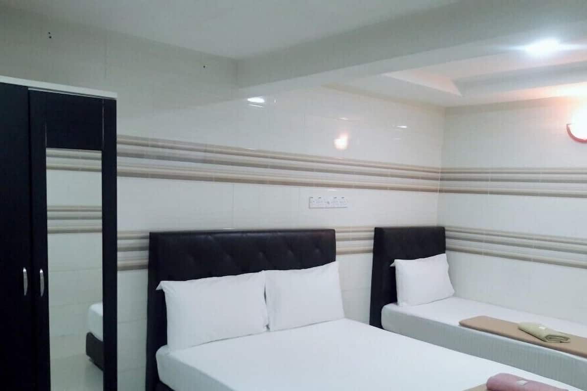Une chambre d’hôtel avec deux lits, une armoire et un miroir.