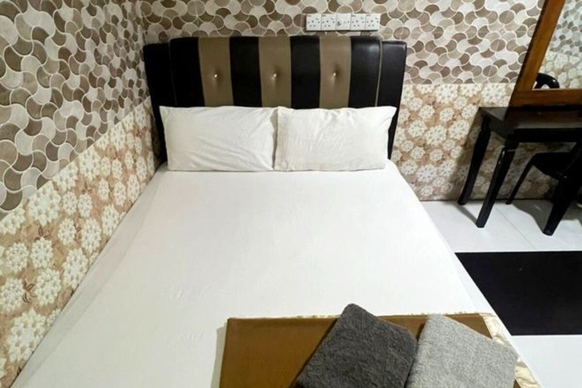 A bed with a striped headboard, a white mattress, and two pillows.