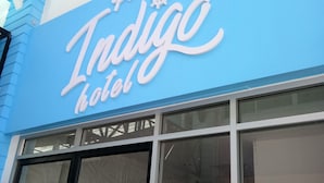 Un letrero de hotel con el nombre 'Indigo' en letras estilizadas.