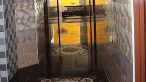 Un pasillo con paredes decoradas, suelo reflectante y alfombra estampada.