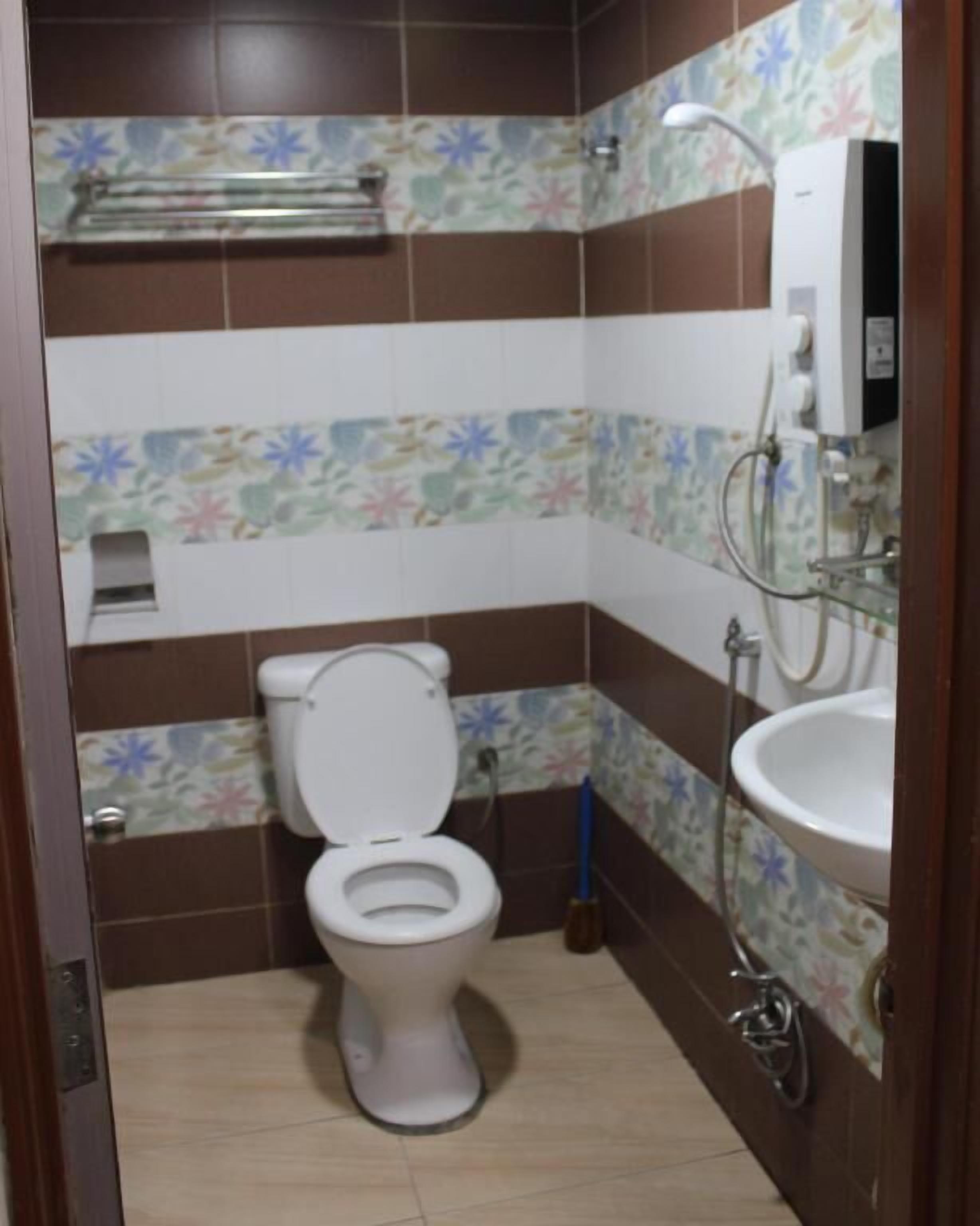 A small bathroom with a toilet, sink, and shower.