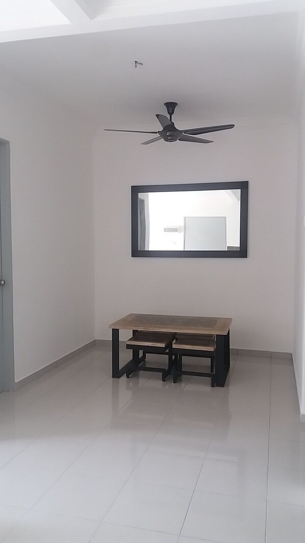 Una habitación amplia con ventilador de techo, un espejo grande y un banco de madera.