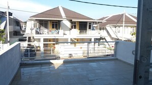 A residential building with a balcony, a staircase, and a gated entrance. - Kasa Heights Homestay (Alor Gajah)