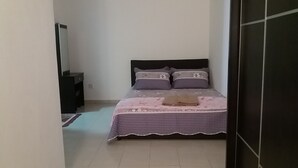 A bedroom with a bed, a nightstand, a dresser, and a mirror. - Kasa Heights Homestay (Alor Gajah)