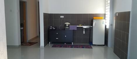 A compact kitchen with a refrigerator, a sink, and a coffee maker.