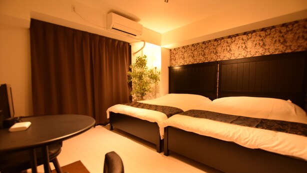 A hotel room with a bed, a desk, and a chair. - MT House Bentencho (Osaka)