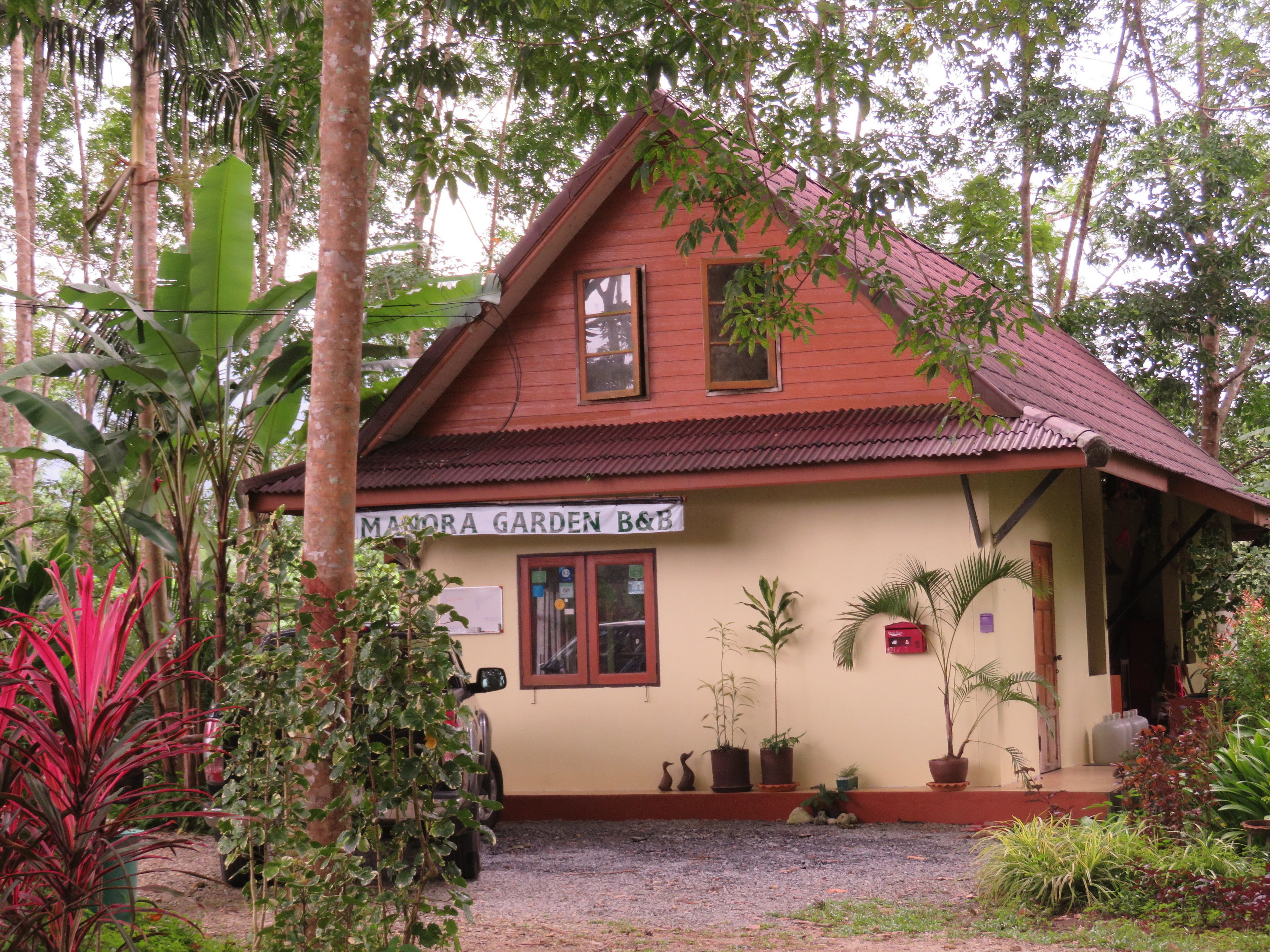 A two-story building with a sign reading "Manora Garden B&B".