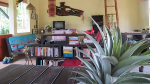 Una sala de estar acogedora con una mesa de madera, una estantería y un televisor.