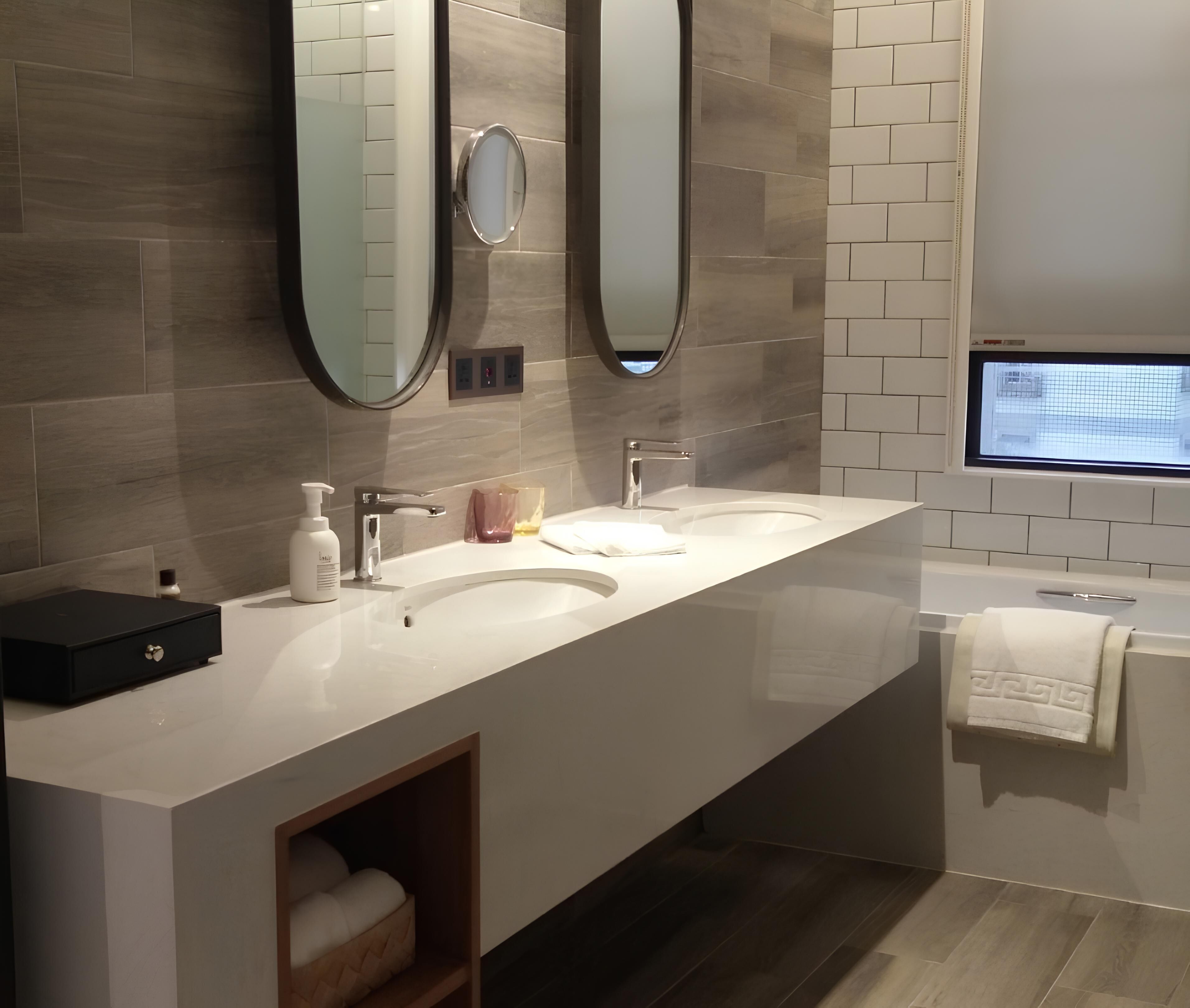 Een moderne badkamer met twee wastafels, een grote spiegel en een inbouw raam.